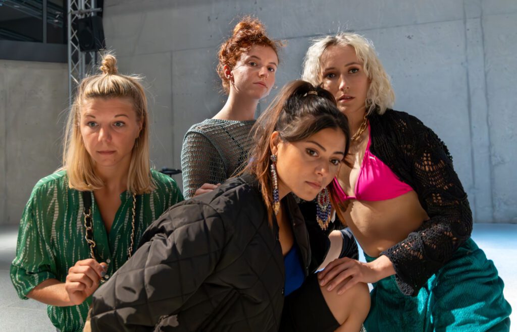 Vier junge Frauen blicken skeptisch auf einen Punkt in der Ferne im Stück seven lives - none left